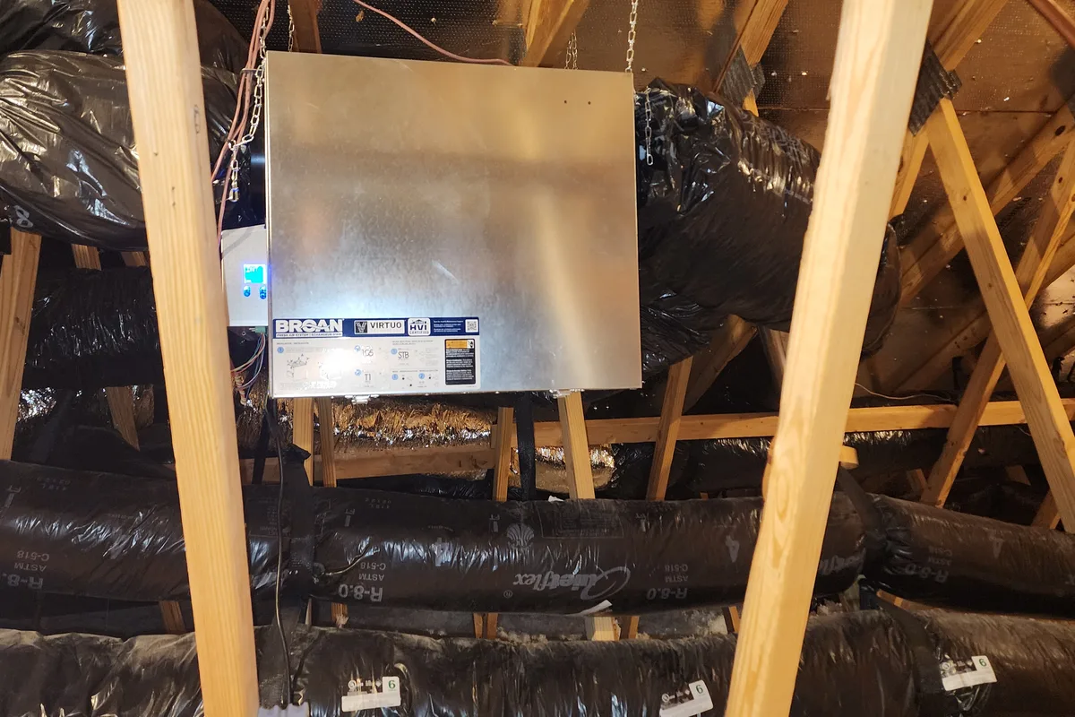 Broan Virtuo ERV suspended from attic rafters with insulated R-8.0 duct runs connecting to it in a Wake County NC home
