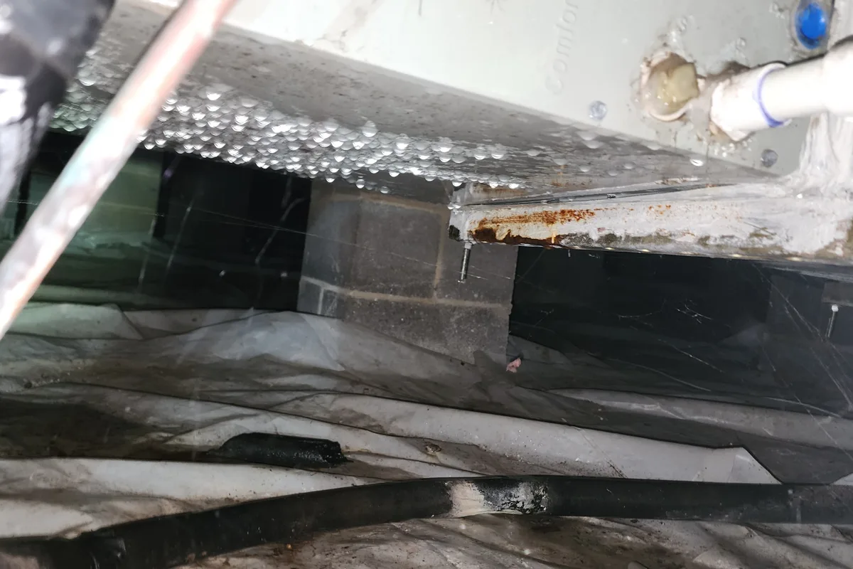Heavy condensation dripping off ductwork and an air handler plenum onto the vapor barrier in a vented Wake County NC crawl space