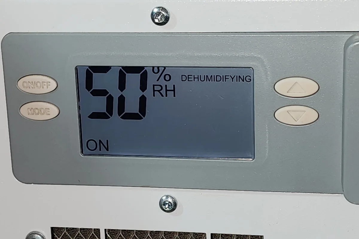 AprilAire whole-house dehumidifier control panel showing 50% RH set point and Dehumidifying status